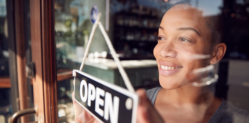 Someone turning an open sign